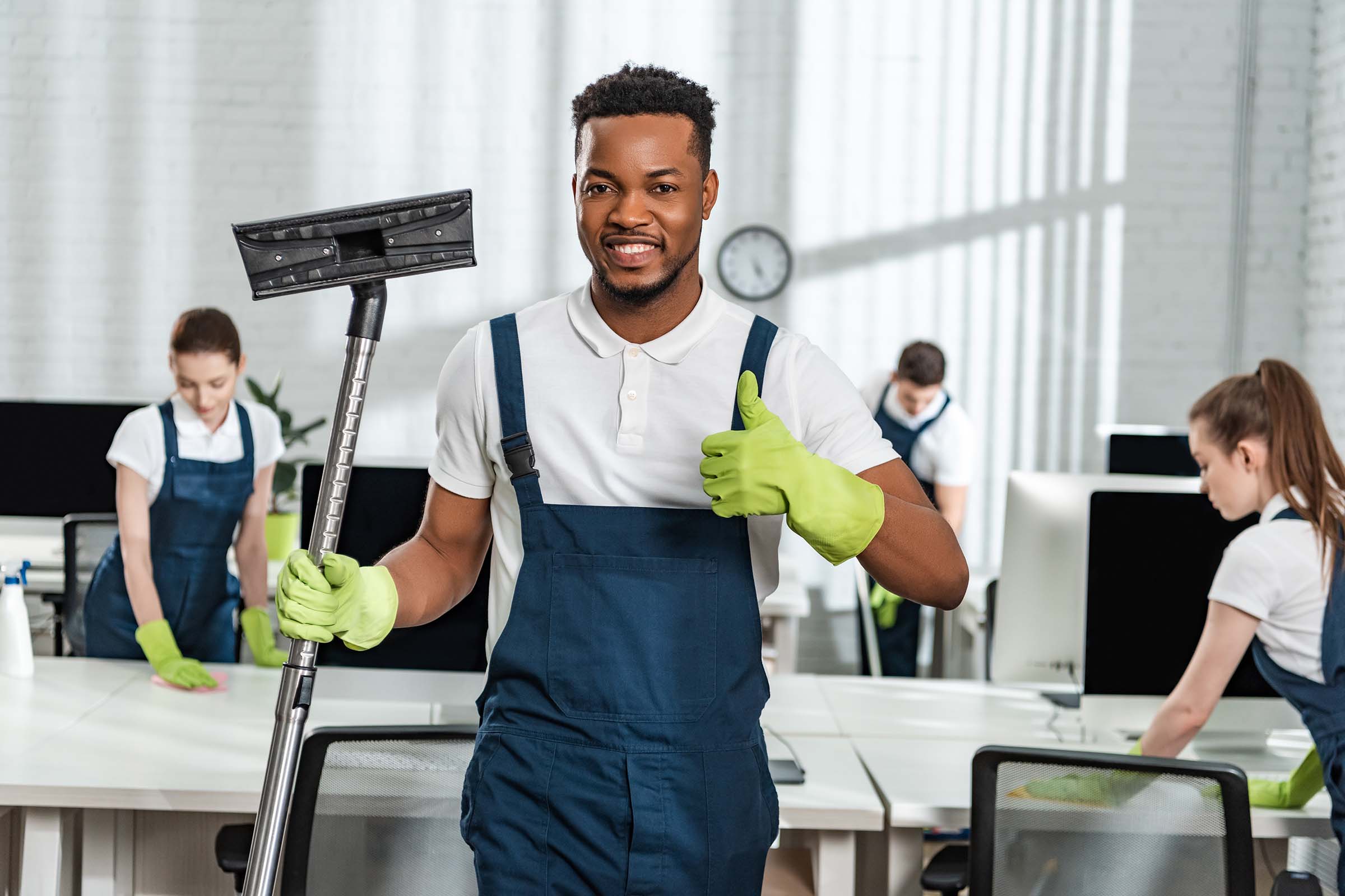 Commercial cleaner holding a vacuum in an office environment