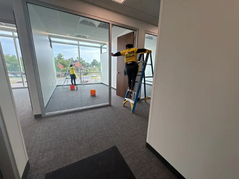 Professional glass cleaning on conference room walls in a Huntsville commercial office