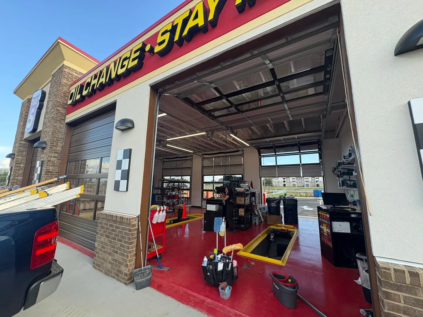 Day porter maintaining the outside exterior of an oil change shop in Huntsville, AL