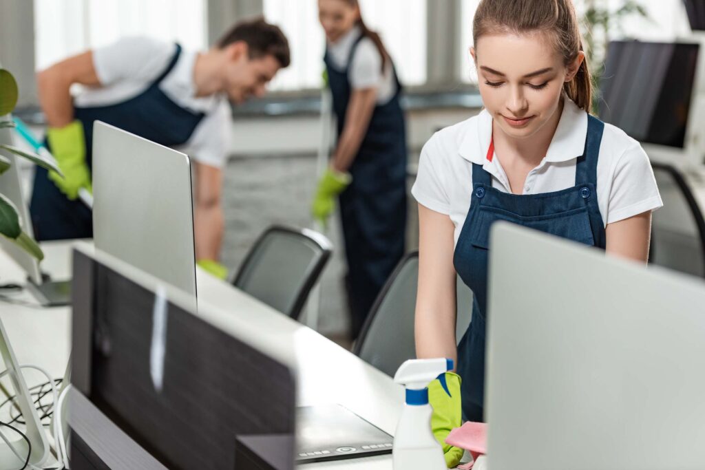 Professional cleaner wiping down a desk for an Albertville, AL business
